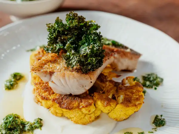 Un délicieux poisson poêlé sur un lit de chou-fleur doré, garni de kale croustillant. Une recette chou-fleur à la poêle qui éveille les papilles.