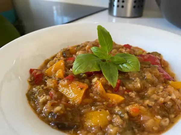 Ratatouille coloré et savoureux, préparé avec le Cookeo, garni d'une feuille de basilic frais.