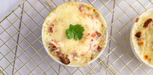 Un gratin de brocolis crémeux et doré, garni d'une feuille de persil, prêt à être dégusté.