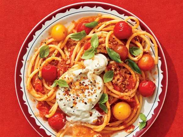 Délicieuse recette de paccheri avec tomates cerises, burrata crémeuse et basilic frais. Un plat coloré et savoureux.