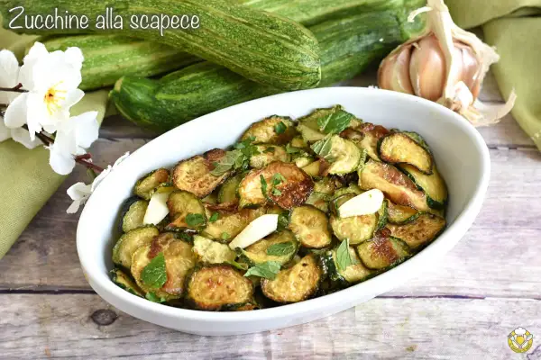Zucchine alla scapece, un plat savoureux de courgettes frites, ail et menthe, servi dans un plat blanc.